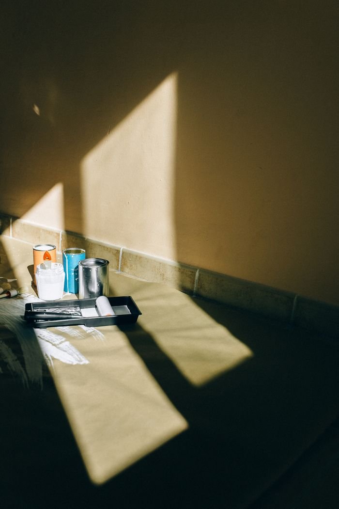 Mastering the First Impression: Your intriguing post title goes here Assorted painting tools casting shadows in a brightly lit room corner.